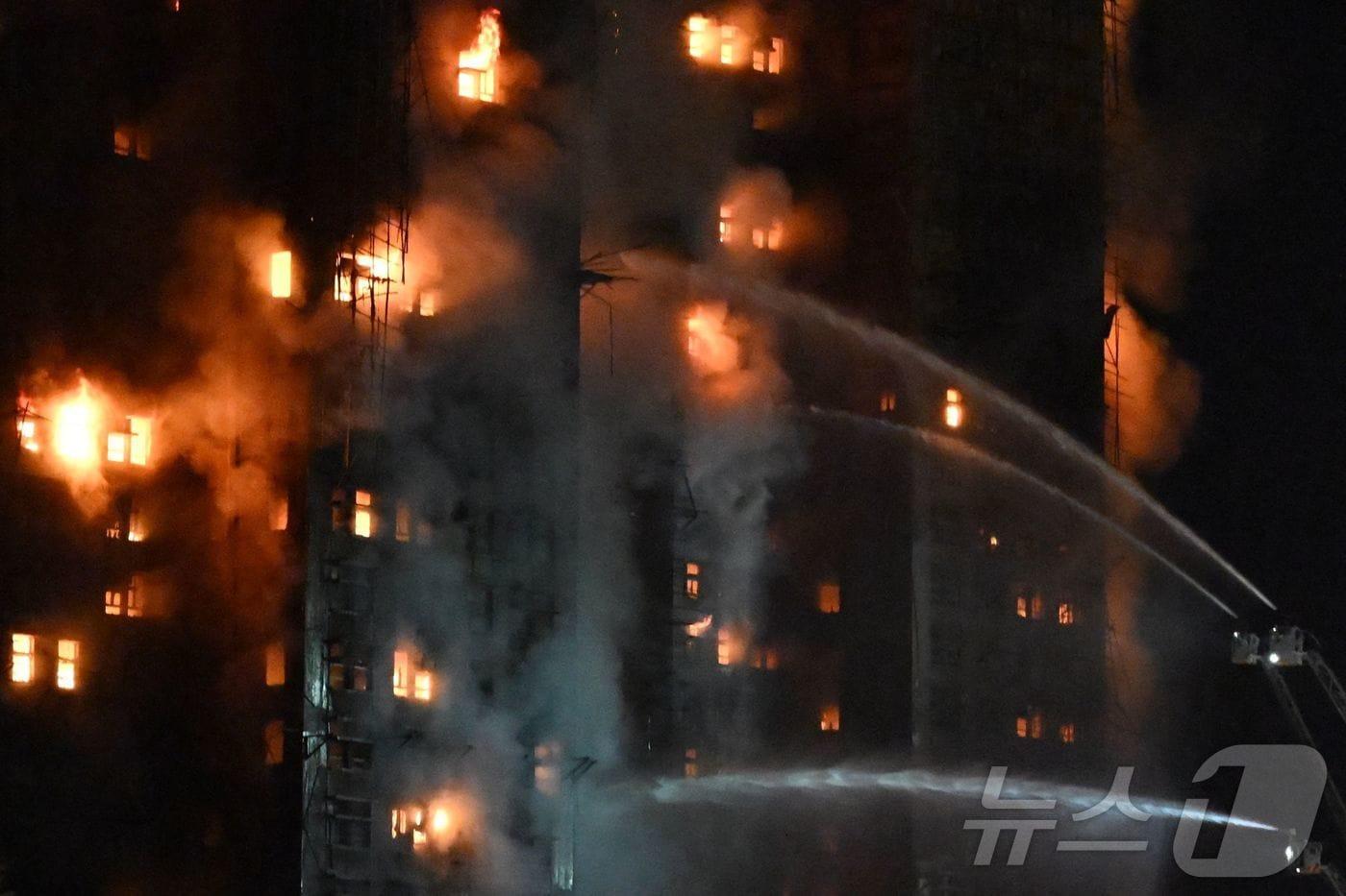 26일 홍콩 타이포 지역의 왕 푹 코트 주거 단지에서 대형 화재가 발생해 소방관들이 물을 뿌리며 진화 작업을 벌였다. 현지 언론은 일부 주민들이 내부에 갇혀 있다고 전했다. 2025.11.26.ⓒ AFP=뉴스1