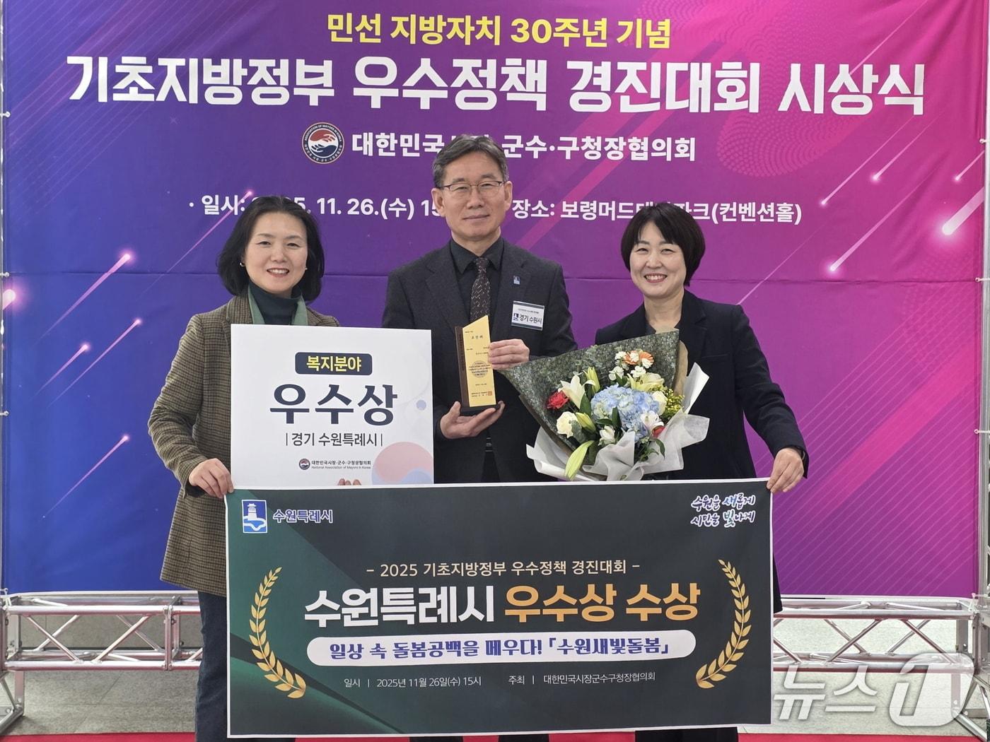 본문 이미지 - 경기 수원시 관계자들이 지난 26일 충남 보령시 보령머드테마파크에서 대한민국시장군수구청장협의회가 주최한 '2025 기초지방정부 우수정책 경진대회'에서 복지분야 우수상을 수상한 후 기념촬영을 하고 있다. (수원시 제공. 재판매 및 DB 금지) 2025.11.27/뉴스1 