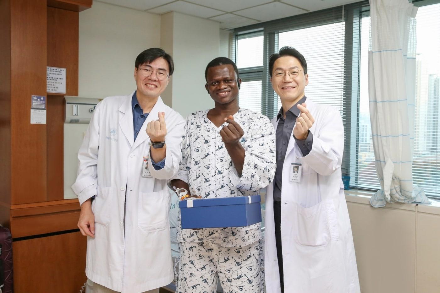 본문 이미지 - 서울아산병원에서 대퇴골 재건 및 피부 이식 수술을 받은 존 콘테 씨(가운데)가 13일 의료진과 기념사진을 찍고 있다. 서울아산병원 김지완 정형외과 교수(왼쪽 첫번째), 권진근 성형외과 교수(왼쪽 세번째).(서울아산병원 제공)