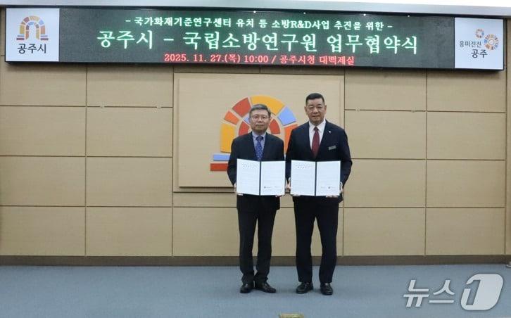 본문 이미지 - 김연상 국립소방연구원장과 최원철 공주시장이 협약서에 서명 후 기념사진을 촬영하고 있다.(소방청 제공)