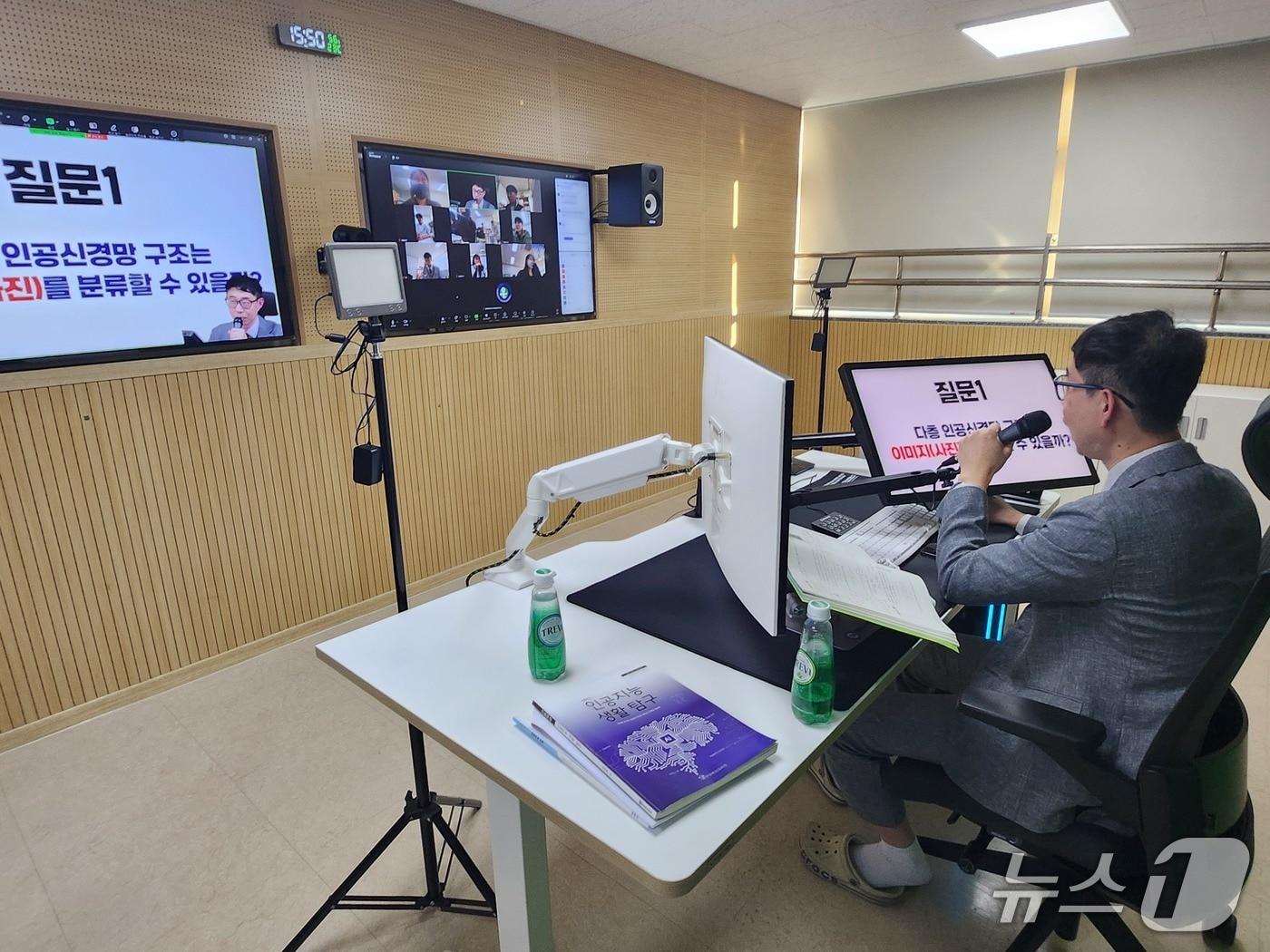 본문 이미지 - &#39;인공지능 수학&#39; 수업을 진행하고 있는 윤정호 교사. 윤 교사의 뒤에는 크로마키 스크린이 설치돼 있다./뉴스1 ⓒ News1 장성희 기자