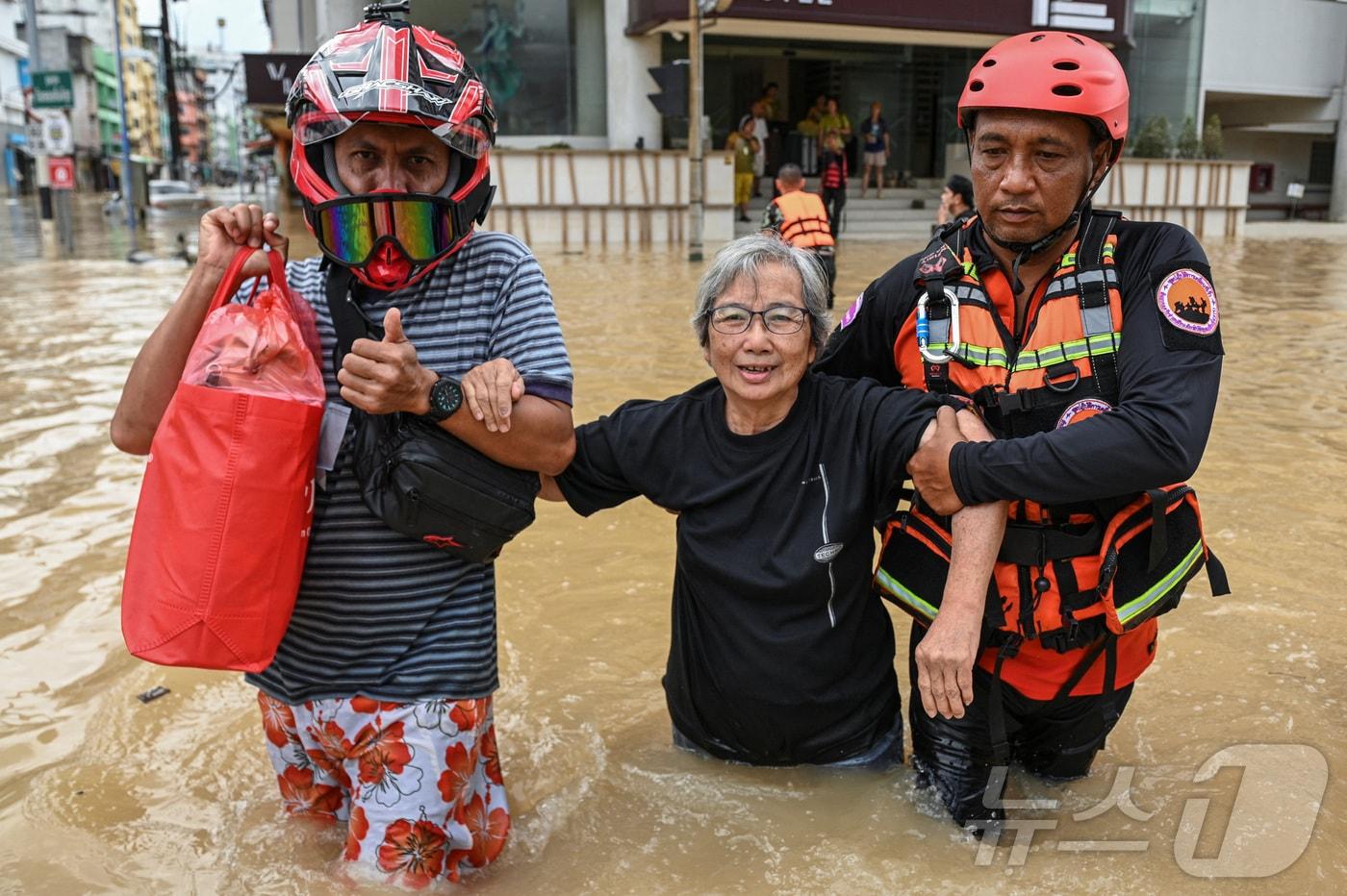 본문 이미지 - 태국 송클라주 핫야이에서 구조 당국이 27일(현지시간) 홍수로 인해 물이 범람한 거리에서 관광객을 대피시키고 있다. 2025.11.27 ⓒ 로이터=뉴스1