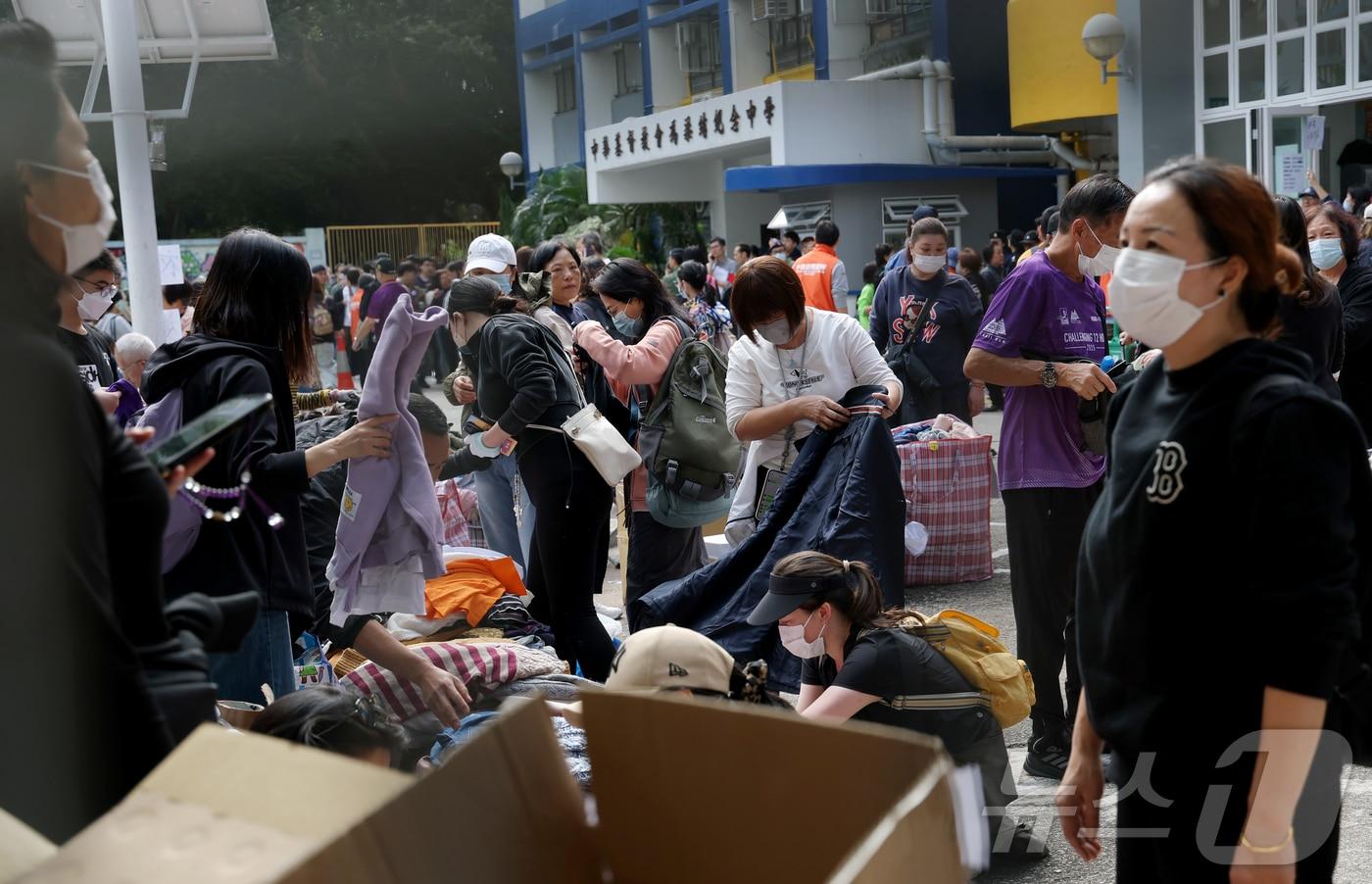 29일&#40;현지시각&#41; 홍콩 북부 타이포의 &#39;왕 푹 코트&#39;&#40;Wang Fuk Court&#41; 아파트 단지 인근 PHAB 센터에서 이재민들이 구호물품을 받고 있다. 2025.11.29/뉴스1 ⓒ News1 권현진 기자