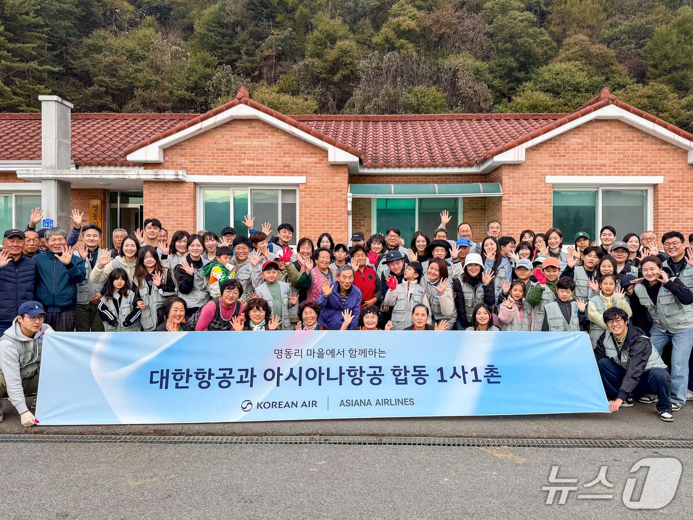 본문 이미지 -  봉사활동에 참여한 대한항공·아시아나항공 양사 임직원과 가족들이 명동리 주민들과 기념사진을 촬영하는 모습.&#40;대한항공 제공&#41;