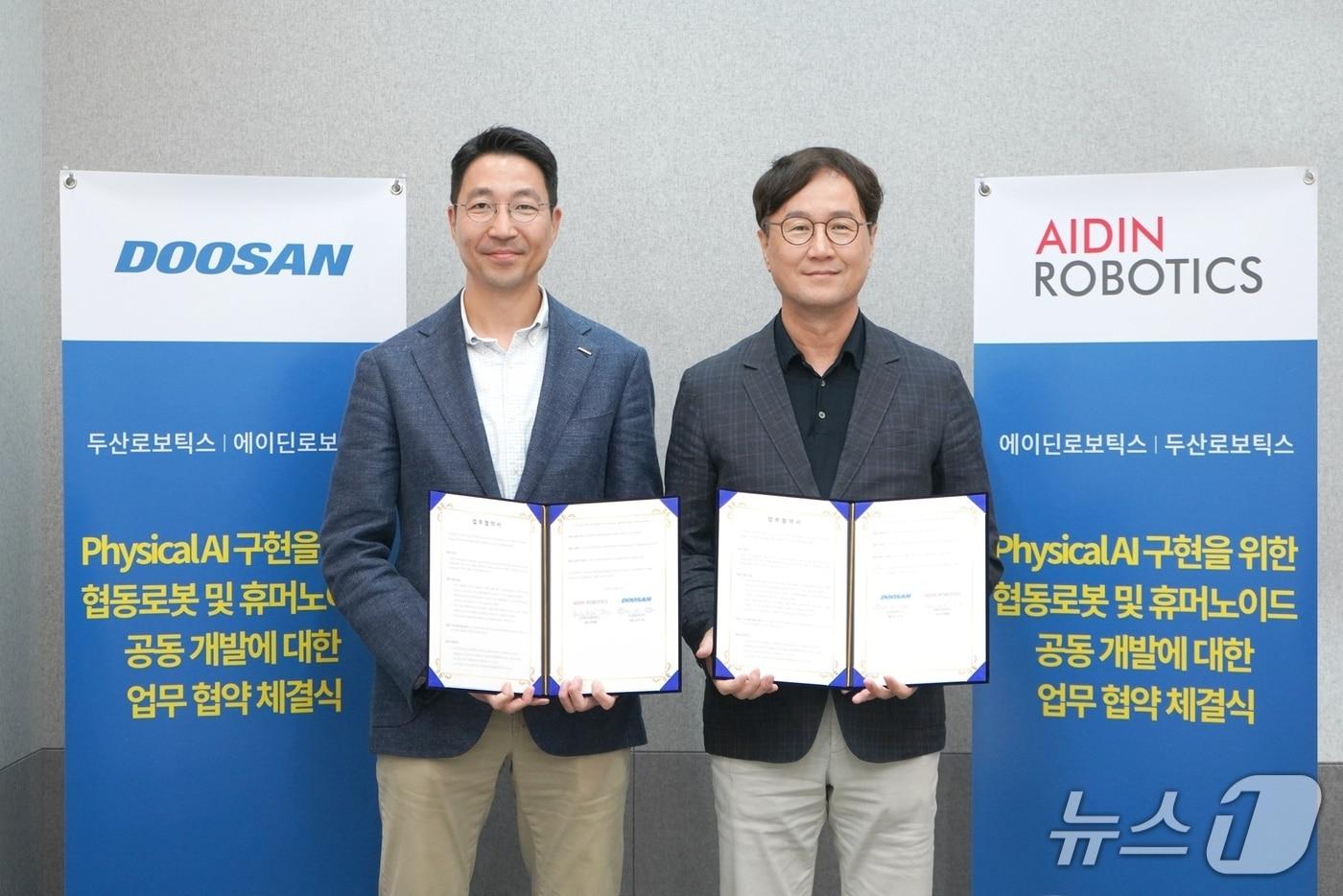 김민표 두산로보틱스 대표(왼쪽)와 최혁렬 에이딘로보틱스 대표가 기념 촬영을 하고 있다.(두산로보틱스 제공)