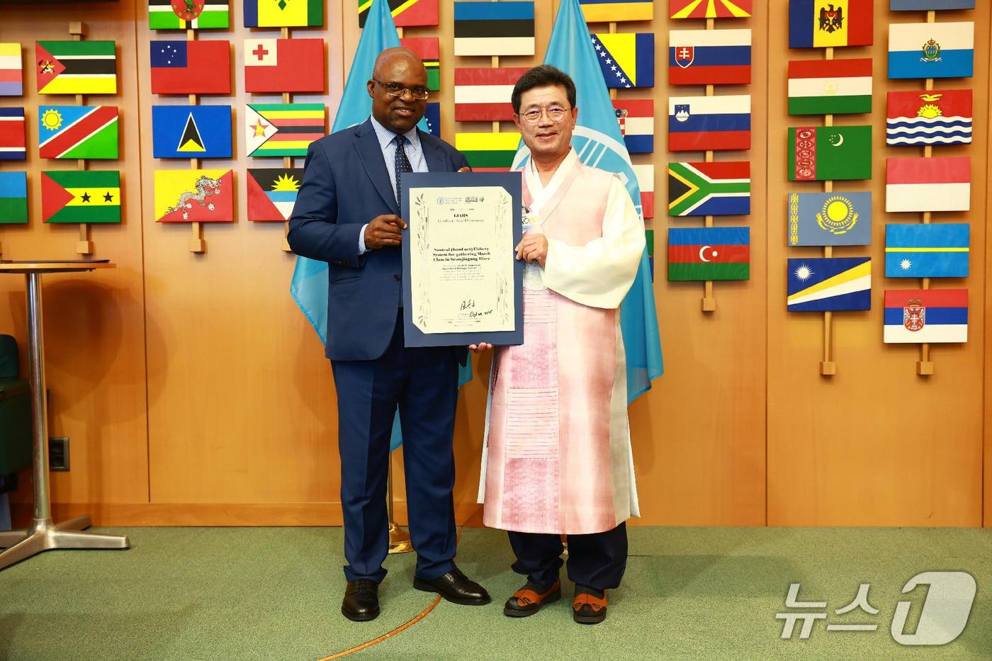 지난달 31일 이탈리아 로마 유엔식량농업기구&#40;FAO&#41; 본부에서 유엔식량농업기구 고드프리 마그웬지&#40;Godfrey Magwenzi, 짐바브웨&#41; 부사무총장이 정인화 광양시장에게 &#39;광양 섬진강 재첩잡이 손틀어업&#39;세계중요농업유산&#40;GIAHS&#41; 인증서를 전달하고있다.&#40;광양시 제공&#41; 