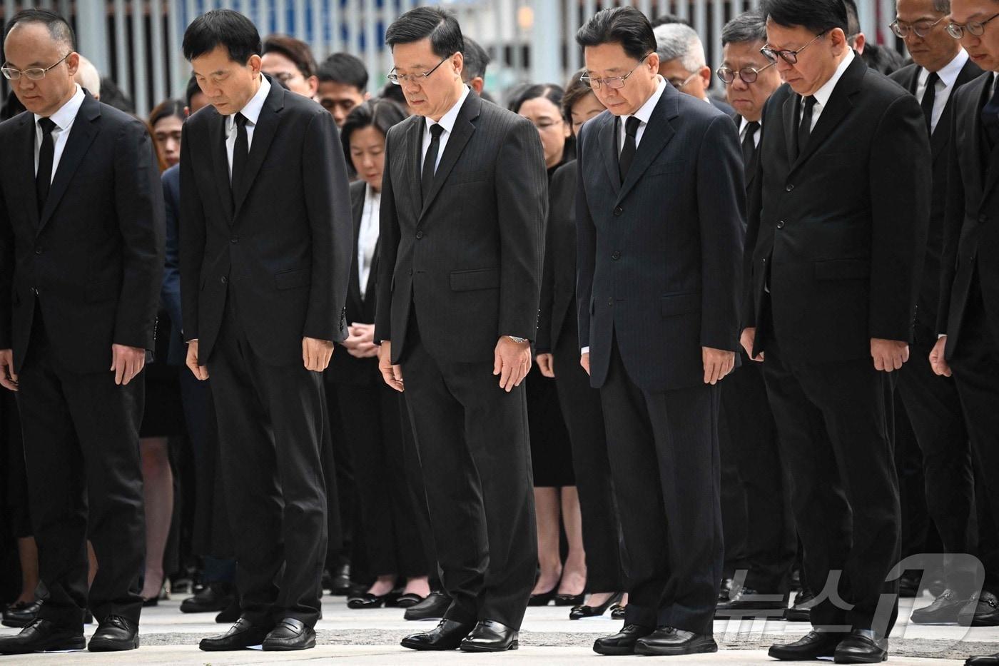 29일 존 리 행정장관 등 홍콩 정청의 간부들이 센트럴에 위치한 정부청사 앞에서 아파트 화재 참사에 희생된 이들을 위해 묵념하고 있다. ⓒ AFP=뉴스1 ⓒ News1 박형기 기자