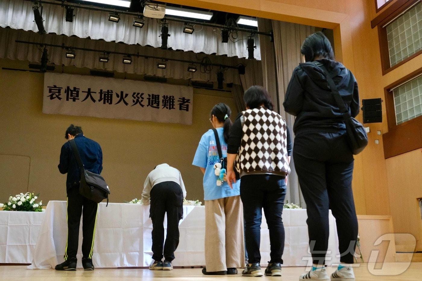 29일 홍콩 타이포 지역에 설치된 아파트 화재 희생자 분향소에서 시민들이 희생자의 넋을 기리고 있다. ⓒ AFP=뉴스1 ⓒ News1 박형기 기자