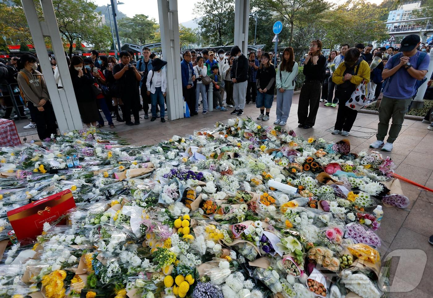 29일 홍콩 타이포 지역에서 설치된 아파트 화재 희생자 추념 공간에서 시민들이 헌화하고 있다. ⓒ 로이터=뉴스1 ⓒ News1 박형기 기자