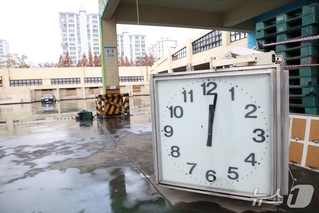 본문 이미지 - 지난해 11월 28일 정오쯤 청과동 붕괴로 전기가 끊기며 멈춰 선 시계가 시장 안에 놓여 있는 모습. 안양시는 이 시계를 사고의 기억물로 보존하는 방안을 검토하고 있다.&#40;안양시 제공. 재판매 및 DB금지&#41;/뉴스1