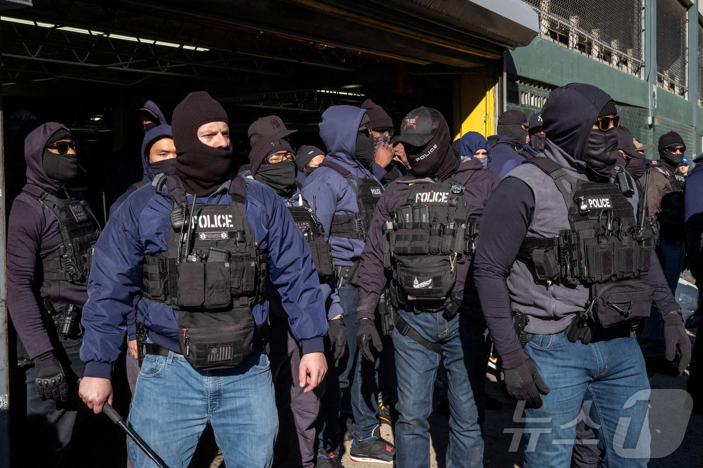 본문 이미지 - 경찰과 미국 이민세관단속국(ICE) 요원들이 29일 뉴욕시 맨해튼 구역의 일반 서비스 관리국(GSA) 주차장 근처에 사람들이 모이는 것을 지켜보고 있다. 2025.11.29 ⓒ 로이터=뉴스1 ⓒ News1 강민경 기자