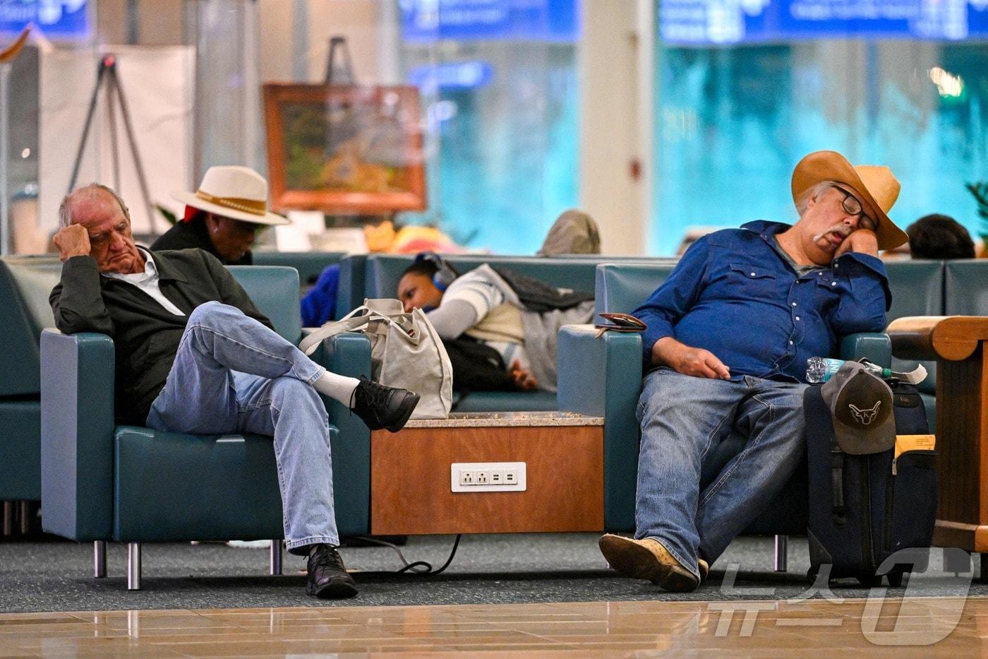 지난달 30일&#40;현지시간&#41; 플로리다주 올랜도 국제공항에서 여행객들이 항공편을 기다리며 의자에서 잠을 청하고 있다. 이날 미 연방항공청&#40;FAA&#41;이 해당 공항 관제탑에 항공관제사가 부족하다고 밝힌 가운데 올랜도 공항 항공편은 심각한 지연을 겪었다. 2025.10.30. ⓒ AFP=뉴스1 