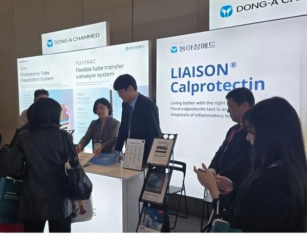 본문 이미지 -  LMCE 2025에서 동아참메드 임직원이 관람객에게 IBD 검사 시약 LIASION Calpotectin을 소개하고 있다. (동아제약 제공)