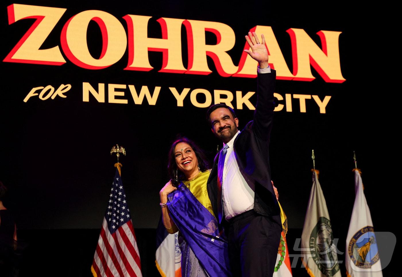 민주당 조란 맘다니&#40;34&#41;가 4일&#40;현지시간&#41; 뉴욕 브루클린에서 어머니 미라 네어 감독과 함께 무대에 올라 지지자들에게 손을 흔들고 있다. 맘다니는 이날 치러진 뉴욕시장 선거에서 개표율 90% 기준 50.4%&#40;102만 9196표&#41;를 득표하면서 41.6%&#40;84만 9816표&#41;를 득표한 앤드루 쿠오모 무소속 후보를 큰 표차로 따돌리며 차기 뉴욕시장으로 당선됐다. ⓒ 로이터=뉴스1 ⓒ News1 윤다정 기자