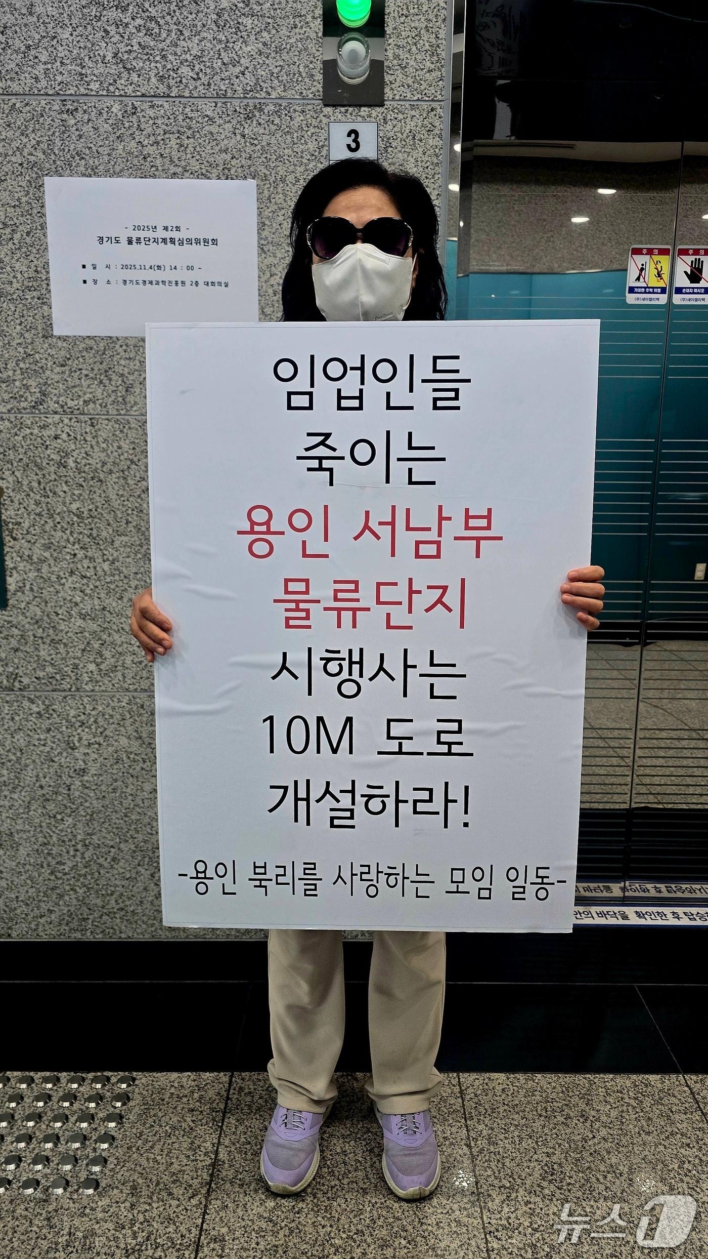 본문 이미지 - 용인시 남사읍 주민이 경기도물류단지계획심의위원회가 열린 경기도경제과학진흥원 앞에서 도로개설을 요구하며 1인 시위를 하고 있다.(독자 제공)