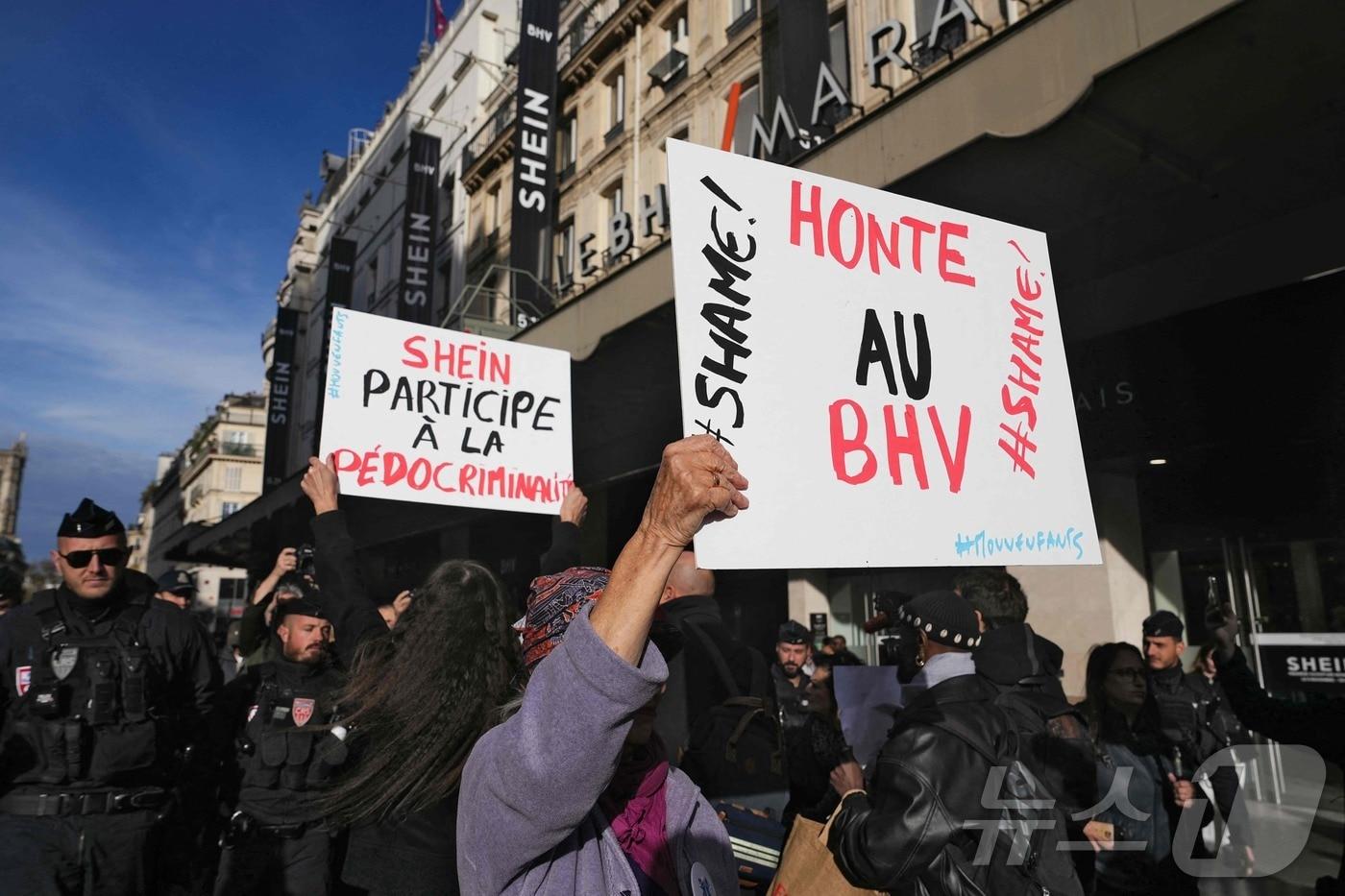 5일(현지시간) 쉬인이 첫 오프라인 매장을 연 프랑스 파리 BHV 마레 백화점 앞에서 한 여성이 'BHV는 부끄러운 줄 알라'(Shame on BHV)라고 적힌 피켓을 들고 있다. 2025.11.05. ⓒ AFP=뉴스1 