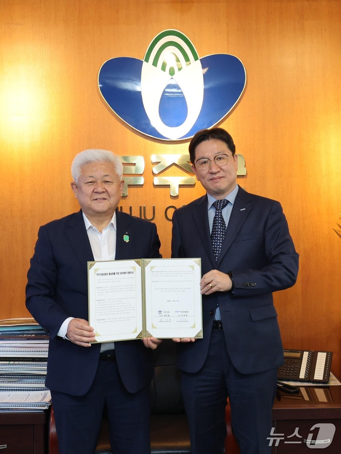 본문 이미지 - 성창훈 사장&#40;오른쪽&#41;과 황인홍 무주군수가 성공적인 모바일 무주사랑상품권 도입 및 운영을 위해 업무협약식을 체결하고 있다. &#40;한국조폐공사 제공.재판매 및 DB금지&#41;/뉴스1