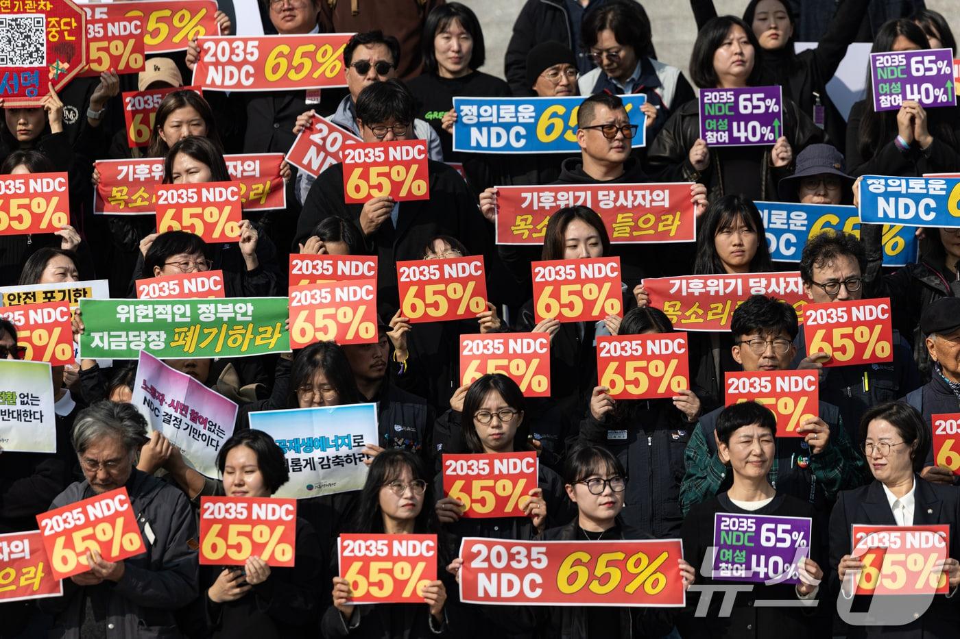 6일 서울 여의도 국회 본청 계단에서 열린 2035 온실가스 감축 목표 65%를 위한 시민집중행동 기자회견에서 참가자들이 온실가스 감축률 최소 65% 설정을 촉구하고 있다. 이날 기후에너지환경부는 2035년 국가 온실가스 감축목표&#40;NDC&#41;를 2018년 대비 50~60% 감축 범위에서 2가지 안을 제시했다. 2025.11.6/뉴스1 ⓒ News1 이승배 기자