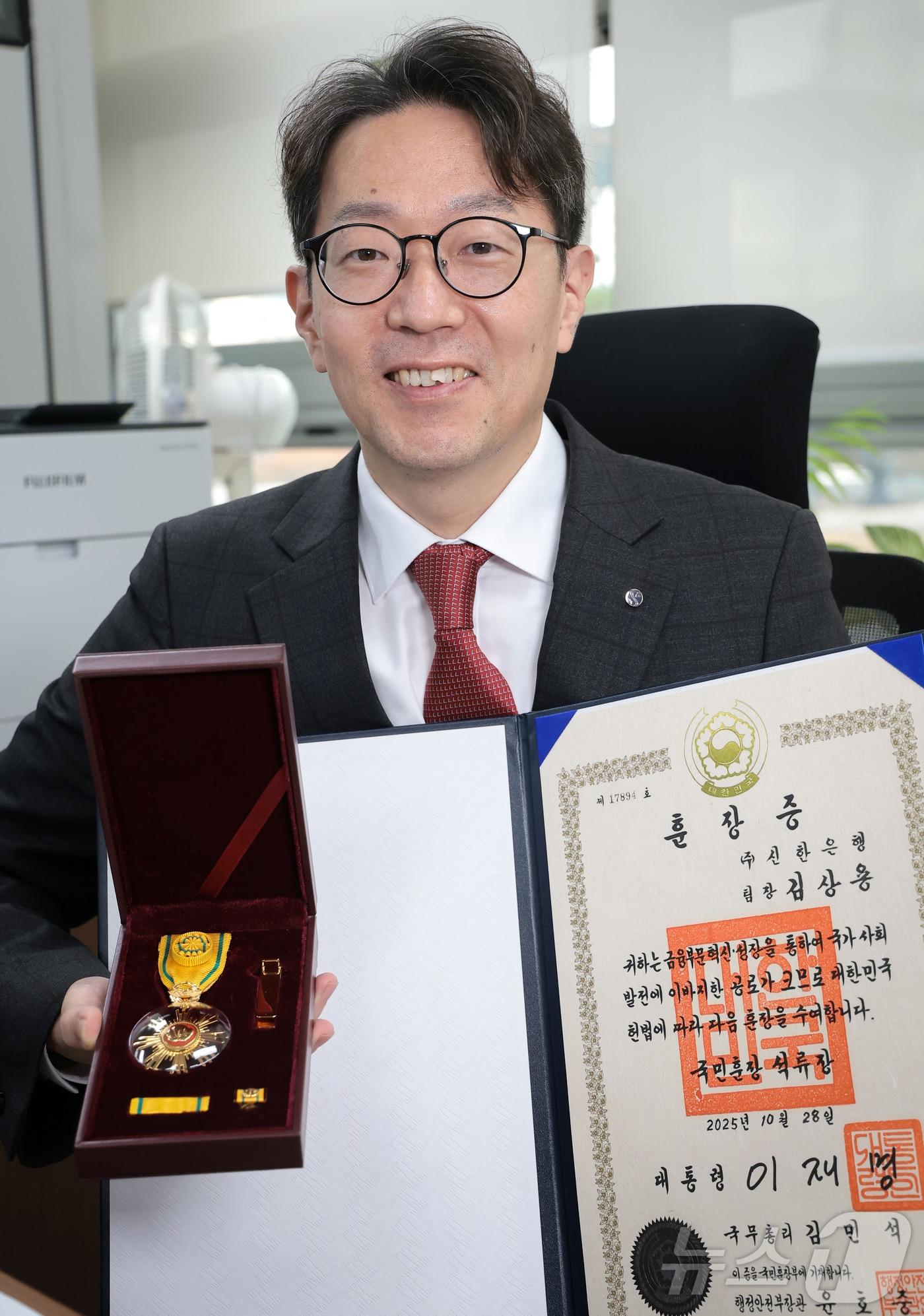본문 이미지 - 김상용 신한은행 고객상담센터 팀장이 6일 서울 강남구 신한은행 강남별관에서 뉴스1과 인터뷰 전 훈장을 들고 포즈를 취하고 있다. ⓒ News1 권현진 기자