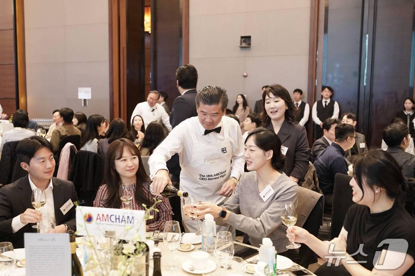 제임스 김 주한미국상공회의소&#40;암참&#41; 회장&#40;왼쪽 세번째&#41;이 6일 서울 여의도 콘래드 서울에서 열린 &#39;암참 최고경영자&#40;CEO&#41; 서버스 나이트&#39;에서 참석자들에게 와인을 따라주고 있다.&#40;암참 제공&#41;
