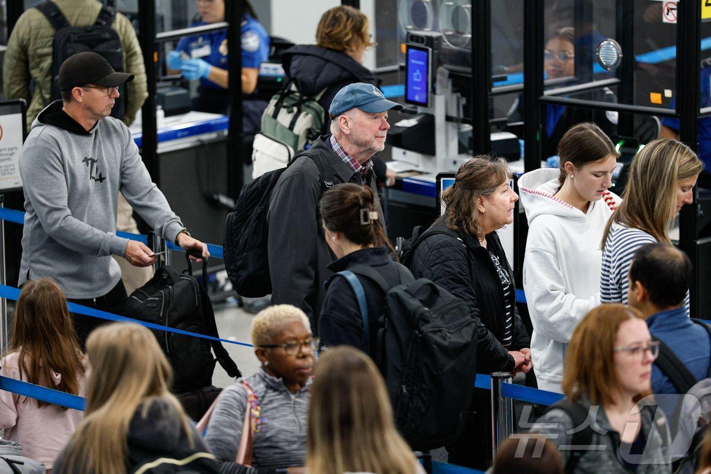 7일&#40;현지시간&#41; 일리노이주 시카고 오헤어 국제공항 보안 검색대에서 여행객들이 줄지어 차례를 기다리고 있다. 연방 정부 셧다운이 이날로 38일째에 접어든 가운데, 트럼프 행정부는 항공 관제사들의 부담을 줄이기 위해 항공편 감축 명령을 내렸다. 2025.11.07. ⓒ AFP=뉴스1 ⓒ News1 류정민 특파원