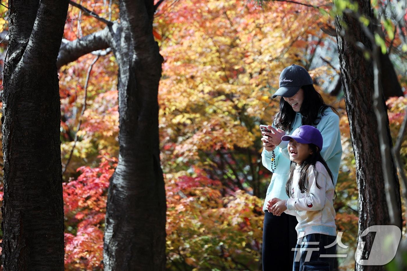 온화한 가을 날씨를 보인 9일 오후 서울 종로구 인왕산 등산로에서 시민들이 단풍과 함께 즐거운 시간을 보내고 있다. 2025.11.9/뉴스1 ⓒ News1 황기선 기자