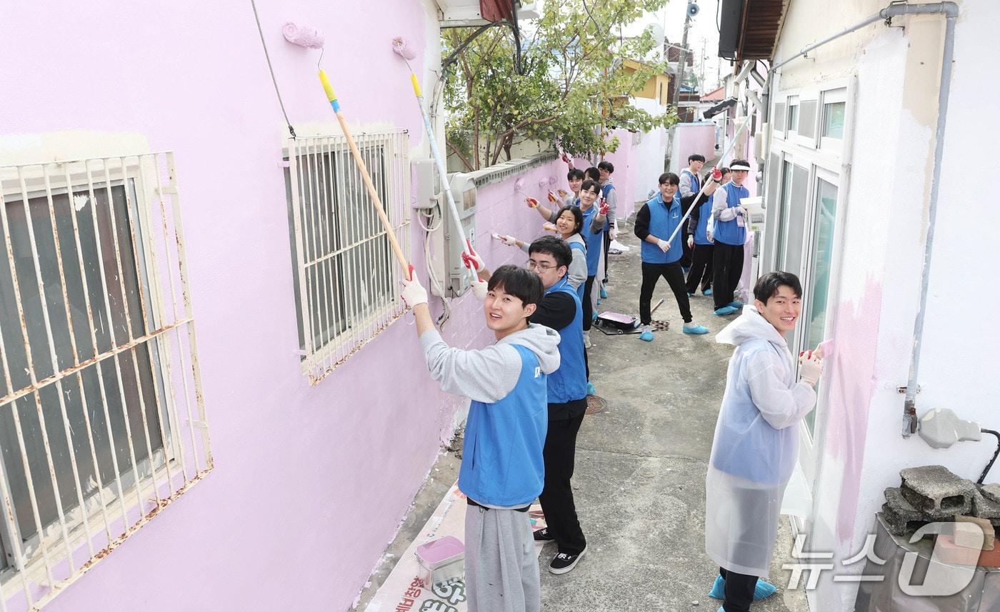 두산에너빌리티 신입사원들이 창원시 진해구 아랫장천마을에서 진행된 사회공헌활동에서 골목길 벽면 도색 환경개선 봉사활동을 하고 있다.&#40;두산에너빌리티 제공. 재판매 및 DB 금지&#41;