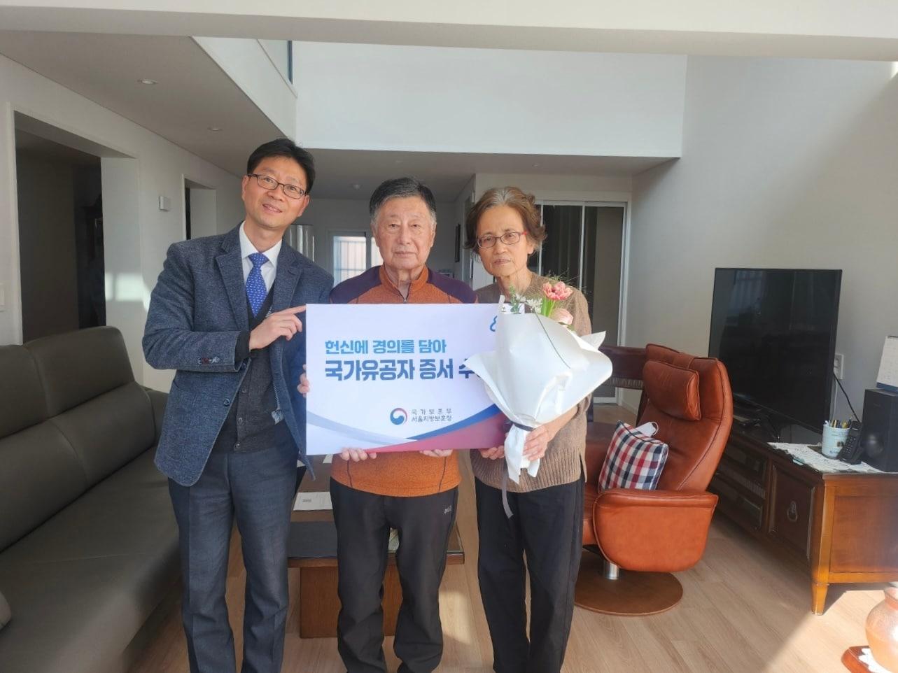 본문 이미지 - 정창호 서울지방보훈청 보상과장이 무공수훈자 고&#40;故&#41; 송 모 씨의 자녀에게 국가유공자 증서를 전달하고 있다.&#40;서울지방보훈청 제공&#41;