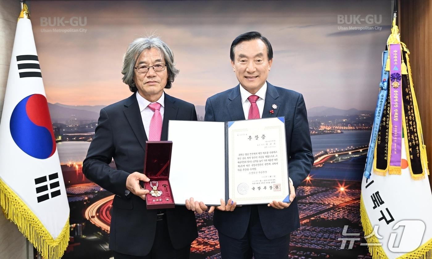 박천동 울산 북구청장&#40;오른쪽&#41;이 1일 구청장실에서 6·25전쟁 당시 혁혁한 무공을 세우고 전사한 고&#40;故&#41; 최규옥 하사의 유족&#40;왼쪽&#41;에게 무성화랑 무공훈장과 훈장증을 전수했다.&#40;울산 북구 제공. 재판매 및 DB금지&#41;/뉴스1