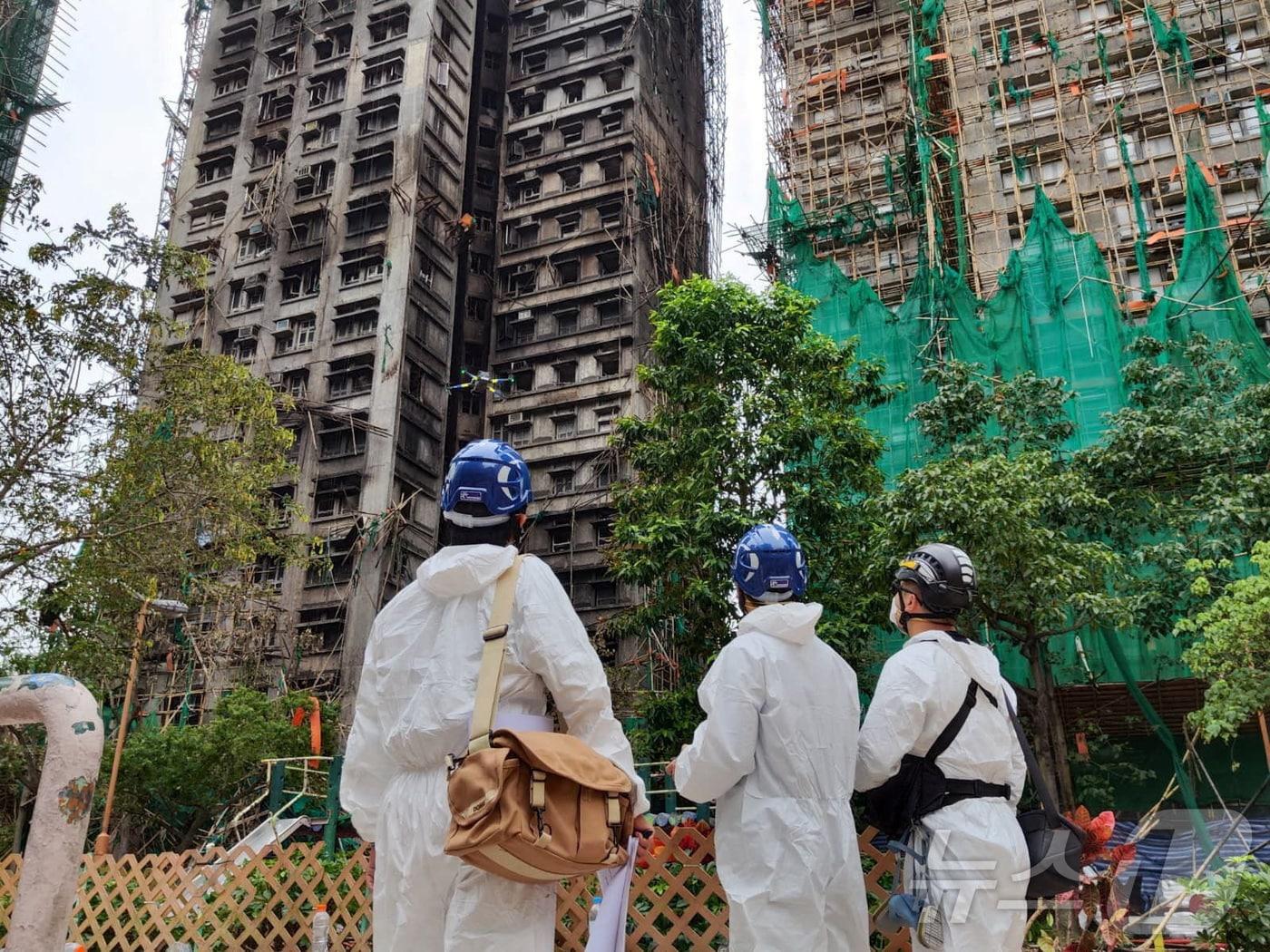본문 이미지 - 홍콩 경찰 관계자들이 화재 참사가 발생한 웡 푹 코트 주변을 둘러보고 있다. 2025.11.30 ⓒ 로이터=뉴스1 ⓒ News1 이지예 객원기자