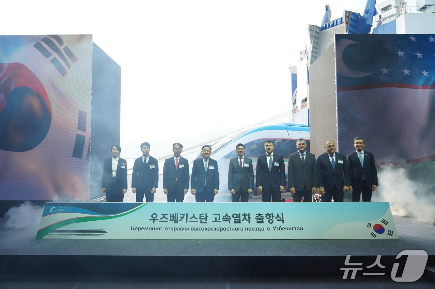 본문 이미지 - 10일 경남 창원시 마산항에서 열린 '우즈벡 고속차량 초도 편성 출항식'에서 관계자들이 기념촬영을 하고 있다. 오른쪽 네번째부터 잠시드 호자예프 우즈베키스탄 경제부총리, 김정훈 현대로템 레일솔루션사업본부장, 허성무 더불어민주당 의원(현대로템 제공) 2025.12.10/뉴스1