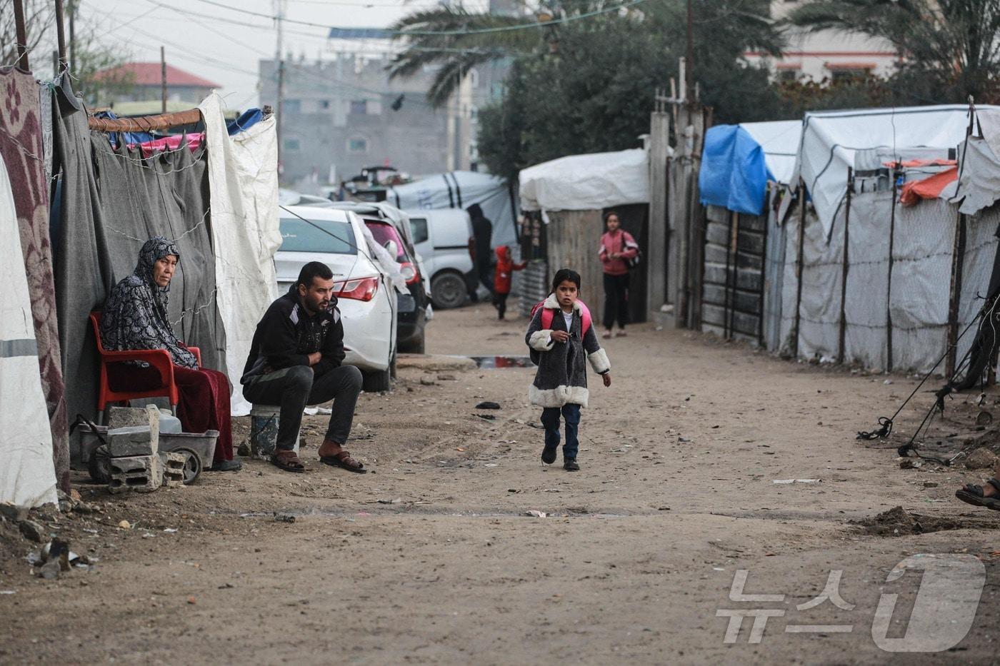 지난달 10일(현지시간) 가자지구 중부 데이르 알 발라에서 한 학생이 학교에 가고 있다. 전날 하마스는 이스라엘의 '위반'이 계속되는 한 가자지구 휴전 계획 2단계로 넘어갈 수 없다며 중재자들에게 이스라엘이 합의를 준수하도록 압력을 가할 것을 촉구했다. 2025.12.10. ⓒ AFP=뉴스1 ⓒ News1 이정환 기자