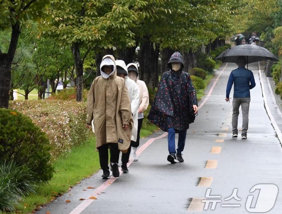 본문 이미지 - 우비를 입은 시민들이 비를 맞으며 걸어가고 있다. / 뉴스1 ⓒ News1