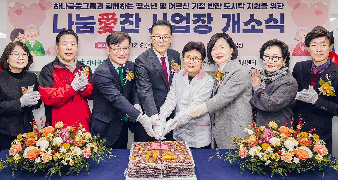 전병권 경인영업본부 지역대표&#40;사진 왼쪽에서 세번째&#41;와 이재호 연수구청장&#40;사진 왼쪽에서 네번째&#41;이 연수구의회 관계자, 도시락 제조시설 시니어 근로자 등과 함께 케이크를 커팅하며 기념촬영을 하고 있다. &#40;하나금융그룹 제공&#41;