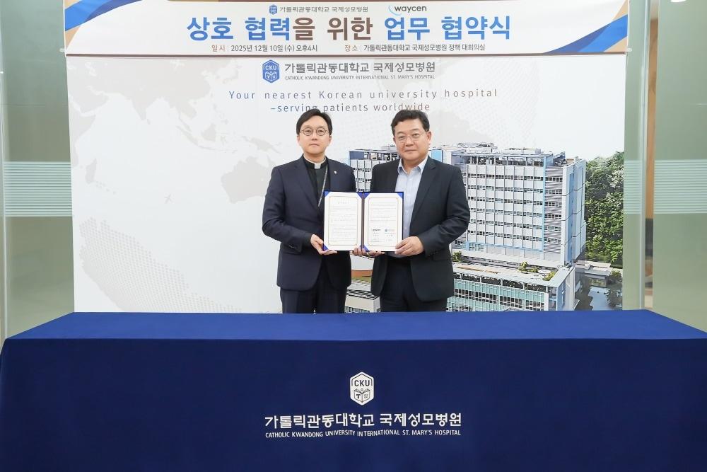 본문 이미지 - 가톨릭관동대학교의료원장 겸 병원장 고동현 신부&#40;좌&#41;와 웨이센 김경남 대표&#40;우&#41;가 협약문을 들고 있다. &#40;웨이센 제공&#41;