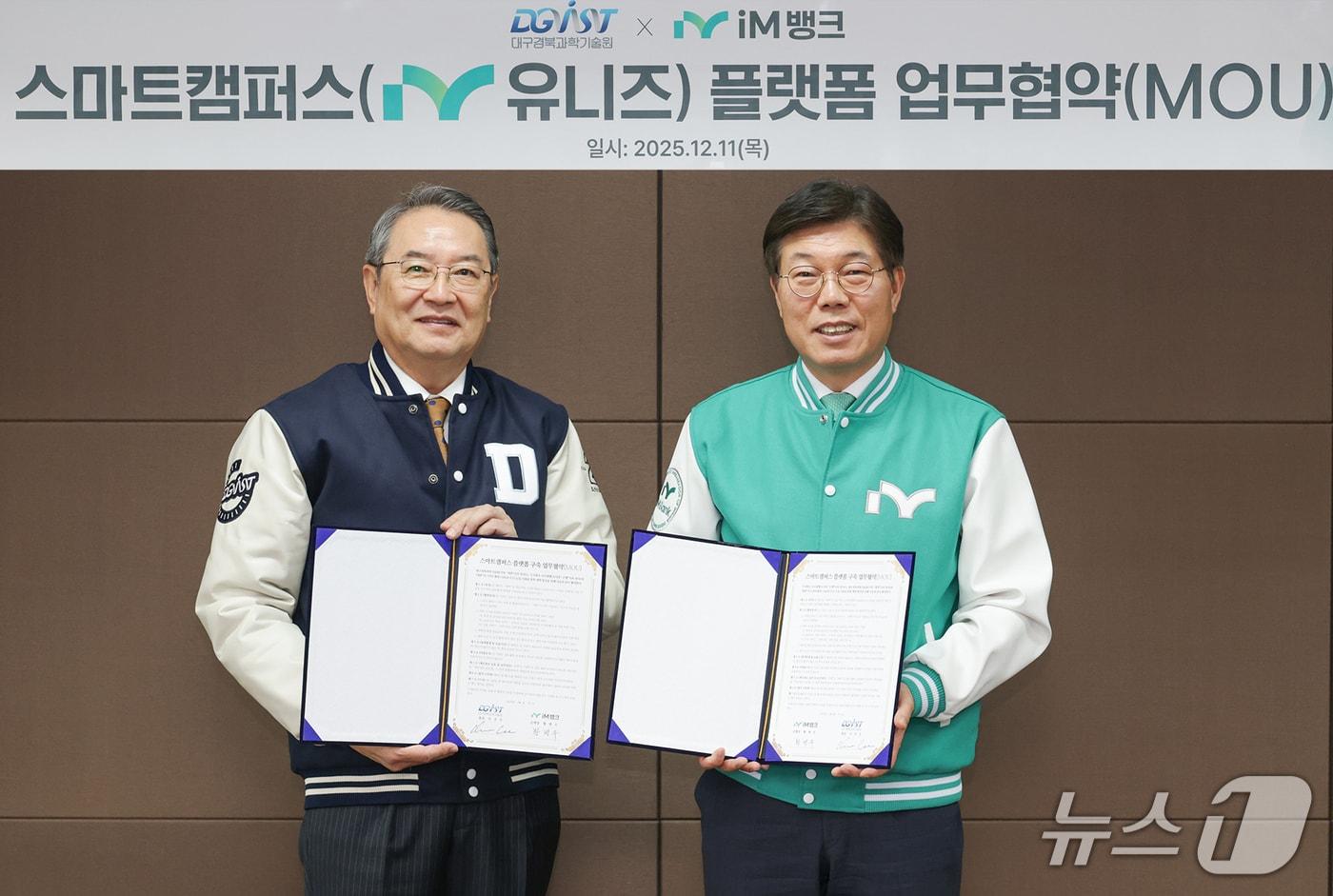 황병우 iM뱅크 은행장&#40;오른쪽&#41;과 이건우 DGIST 총장이 스마트캠퍼스 플랫폼 &#39;아이엠 유니즈&#40;iM uniz&#41;&#39; 구축을 위한 협약을 체결한 뒤 협약서를 펼쳐 보이고 있다.&#40;iM뱅크 제공, 재판매 및 DB 금지&#41;