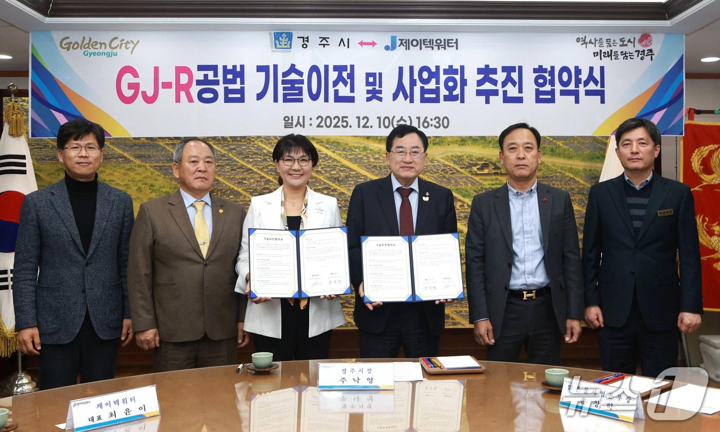 주낙영 경주시장&#40;오른쪽 세번째&#41;과 최윤이 ㈜제이텍워터 대표&#40;왼쪽 세번째&#41;가 &#39;GJ-R 공법&#40;급속처리기술&#41;&#39; 기술이전 및 사업화 추진을 위한 협약을 체결한 뒤 협약서를 펼쳐 보이고 있다.&#40;경주시 제공, 재판매 및 DB 금지&#41;