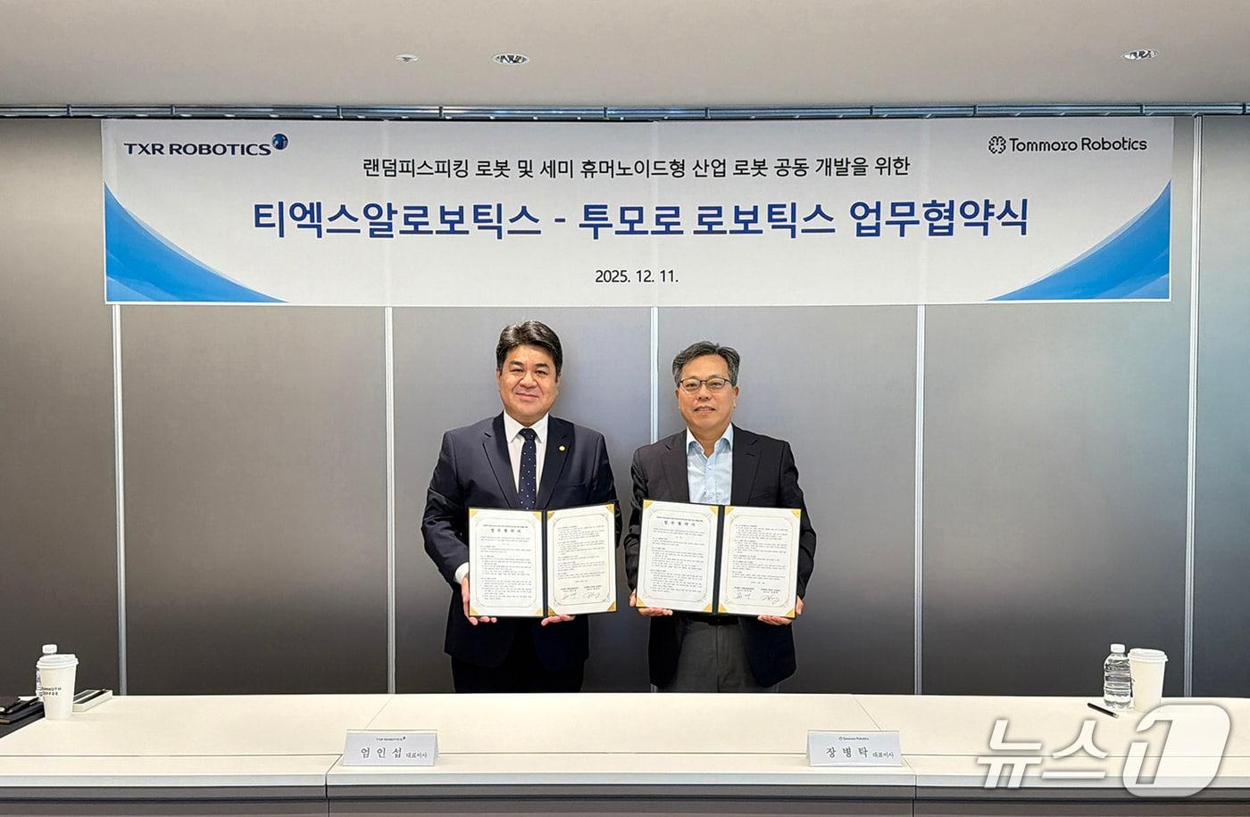 엄인섭 티엑스알로보틱스 대표(왼쪽)와 장병탁 투모로 로보틱스 대표가 지난 11일 서울 티엑스알로보틱스 로봇AI연구소에서 ‘피지컬 AI 기반 세미 휴머노이드 로봇 기술’ 공동 개발을 위한 업무협약을 체결한 뒤 기념촬영을 하고 있다(유진그룹 제공)