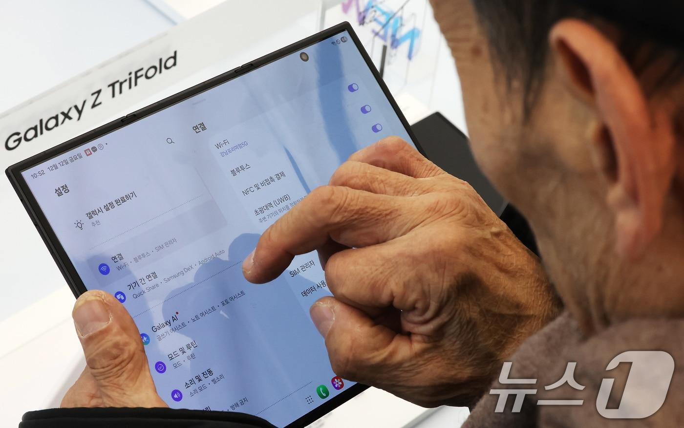 갤럭시 Z 트라이폴드가 출시된 12일 오전 서울 서초구 삼성 강남을 찾은 어르신이 제품을 살펴보고 있다. 2025.12.12/뉴스1 ⓒ News1 장수영 기자