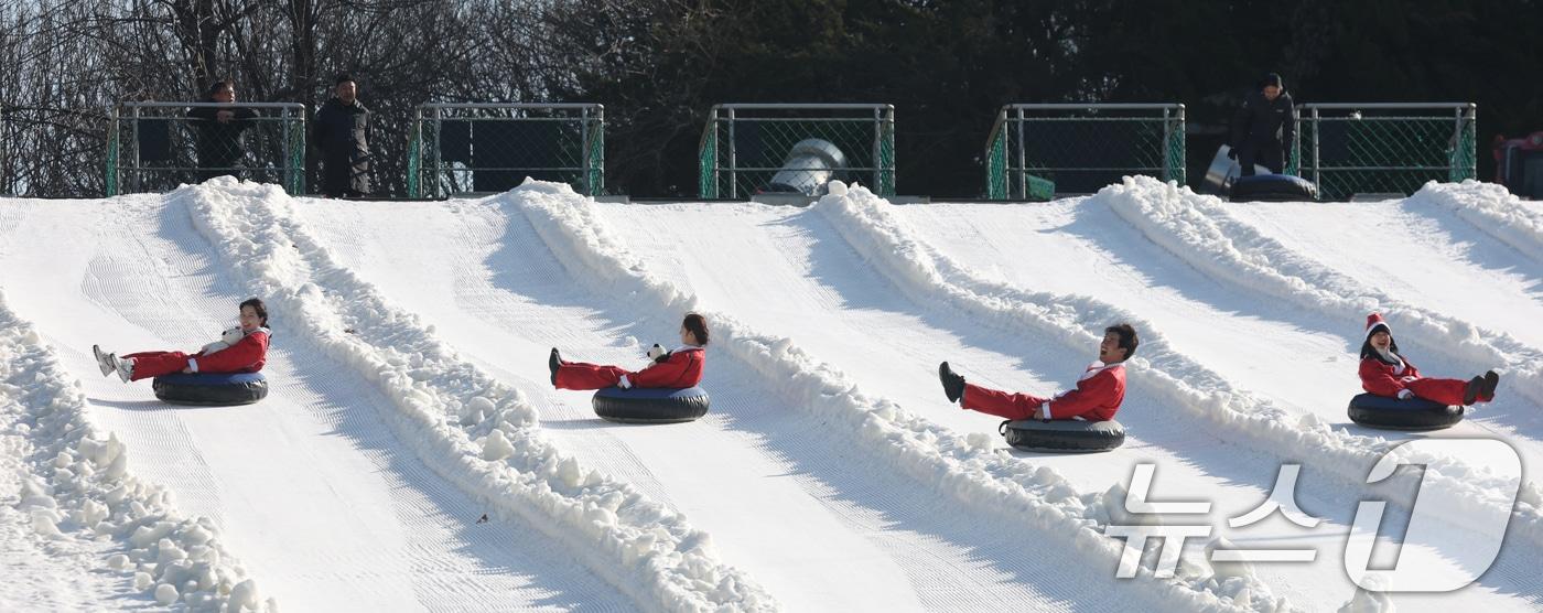 본문 이미지 - 에버랜드 겨울 야외 액티비티 '스노우 버스터'가 개장한 12일 경기 용인시 처인구 에버랜드 눈썰매장 스노우 버스터에서 산타 복장을 한 직원들이 눈썰매를 타고 있다. 2025.12.12/뉴스1 ⓒ News1 김영운 기자