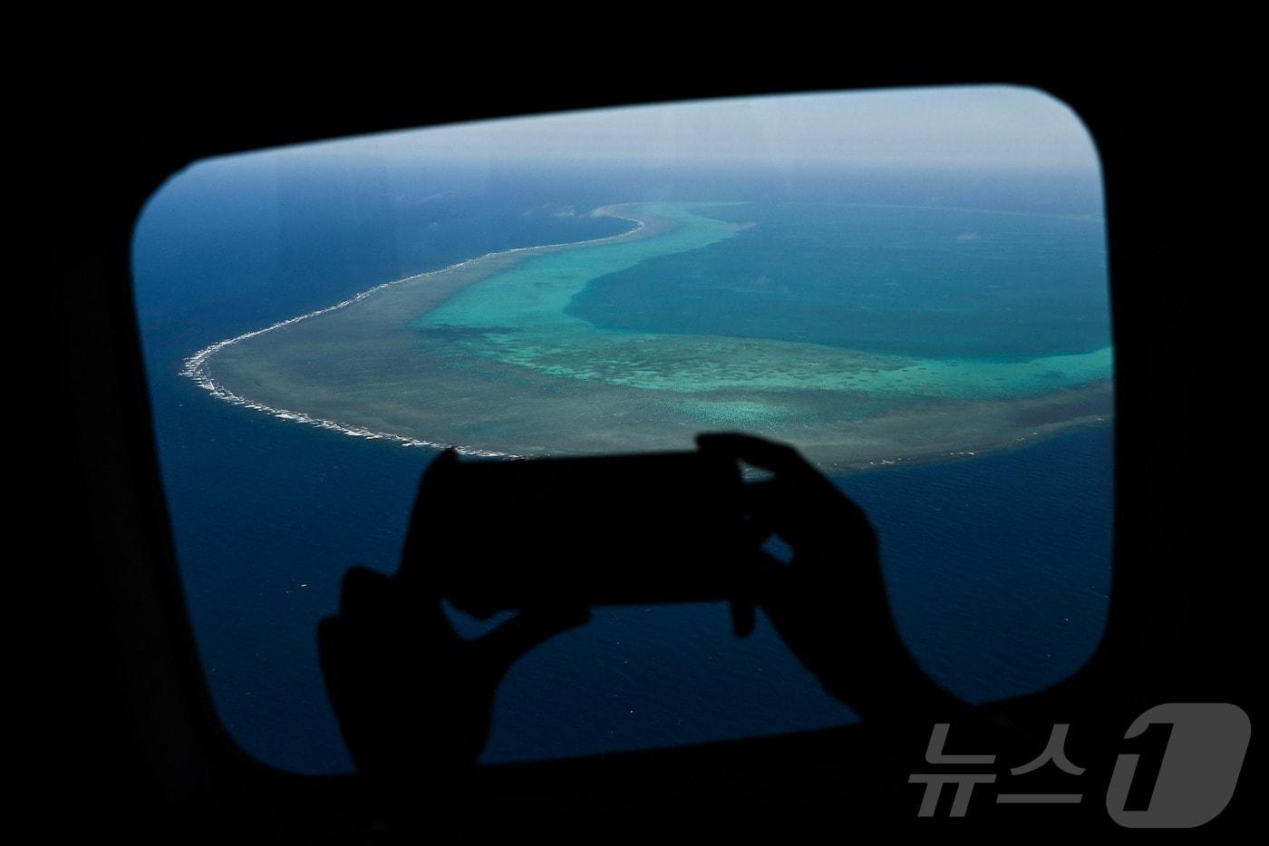  2024년 2월 16일 한 기자가 남중국해 영유권 분쟁 지역인 스카버러 암초 상공에서 영상을 촬영하고 있다. 2024.02.16. ⓒ AFP=뉴스1 ⓒ News1 이정환 기자