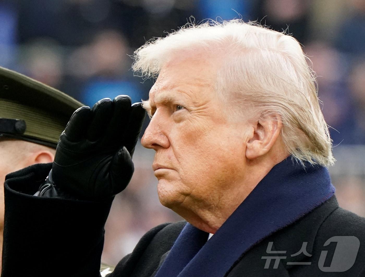 본문 이미지 - 도널드 트럼프 미국 대통령이 13일(현지시간) 메릴랜드주 볼티모어 M&T 뱅크 스타디움에서 열린 육군 대 해군 풋볼 경기에 앞서 미국 국가가 연주되는 동안 거수경례를 하고 있다. 2025.12.13. ⓒ 로이터=뉴스1 ⓒ News1 류정민 특파원