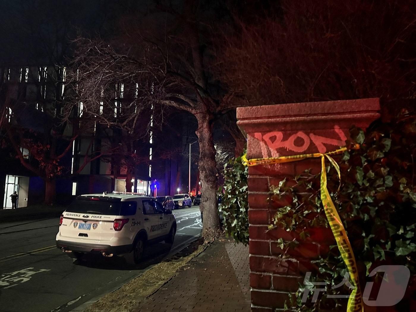 본문 이미지 - 13일&#40;현지시간&#41; 미국 로드아일랜드주 프로비던스 소재 브라운대학교에서 총격 사건이 발생한 직후, 현장에 도착한 경찰차가 통제선이 묶인 벽 인근 도로에 주차돼 있다. 2025.12.13. ⓒ 로이터=뉴스1 ⓒ News1 윤다정 기자