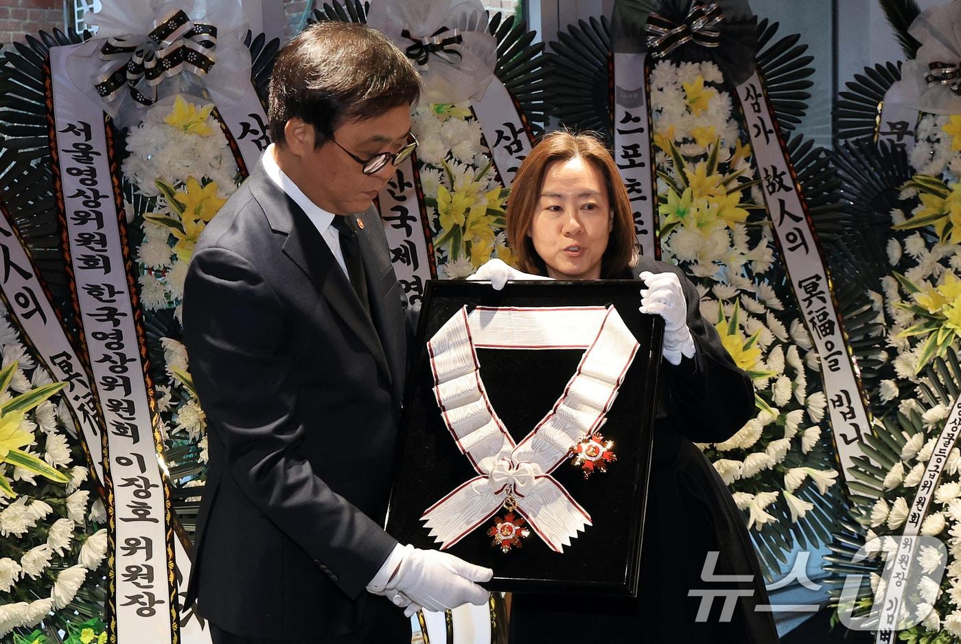 최휘영 문화체육관광부 장관이 14일 서울 중구 서울영화센터에 마련된 고 김지미 배우의 추모공간을 찾아 금관문화훈장을 전달하고 있다. 2025.12.14/뉴스1 ⓒ News1 이호윤 기자