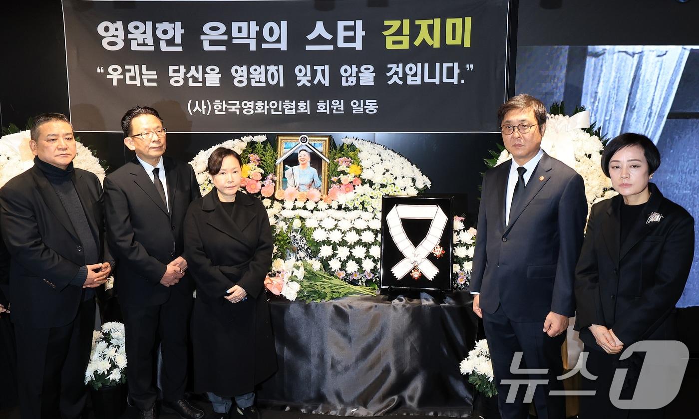 최휘영 문화체육관광부 장관(오른쪽 두 번째)이 14일 서울 중구 서울영화센터에 마련된 고 김지미 배우의 추모공간을 찾아 금관문화훈장을 전달한 뒤 유가족 및 영화업계 관계자들과 기념촬영을 하고 있다. 2025.12.14/뉴스1 ⓒ News1 이호윤 기자
