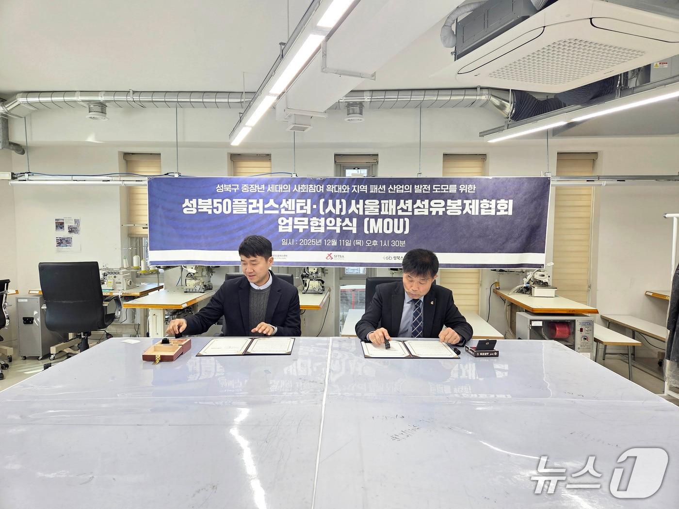 본문 이미지 - 서울패션섬유봉제협회 유지용회장(우)과 성북50플러스센터 김일권 센터장(좌)이 업무협약을 체결하고 있다.(성북구 제공)