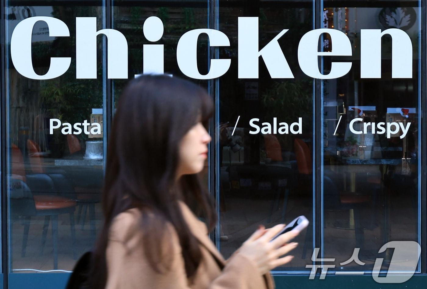 본문 이미지 -  서울 시내의 한 치킨매장 앞으로 시민이 지나가고 있다.  2025.12.15 ⓒ 뉴스1 이호윤 기자