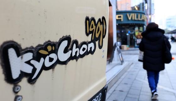 본문 이미지 - 서울 시내의 한 교촌치킨매장 앞으로 시민이 지나가고 있다. 2025.12.15 / ⓒ 뉴스1 이호윤 기자