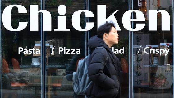 본문 이미지 - 서울 시내의 한 치킨매장 앞으로 시민이 지나가고 있다. 2025.12.15 ⓒ 뉴스1 이호윤 기자