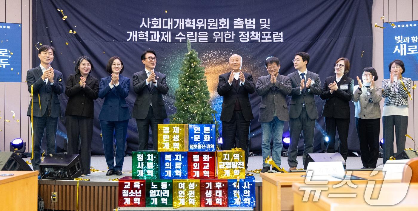 본문 이미지 - 김민석 국무총리가 지난해 12월 15일 서울 여의도 국회박물관에서 열린 사회대개혁위원회 출범 및 개혁과제 수립을 위한 정책포럼에서 위원들과 개혁의 나무 점등식을 하고 있다. 2025.12.15 ⓒ 뉴스1 이승배 기자